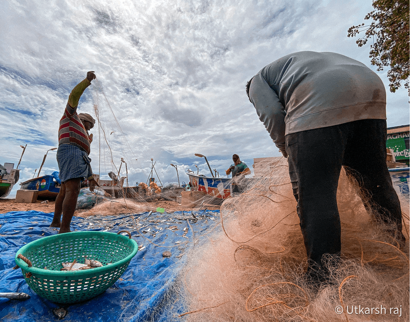 Fishermen pulling and sorting nets on the beach