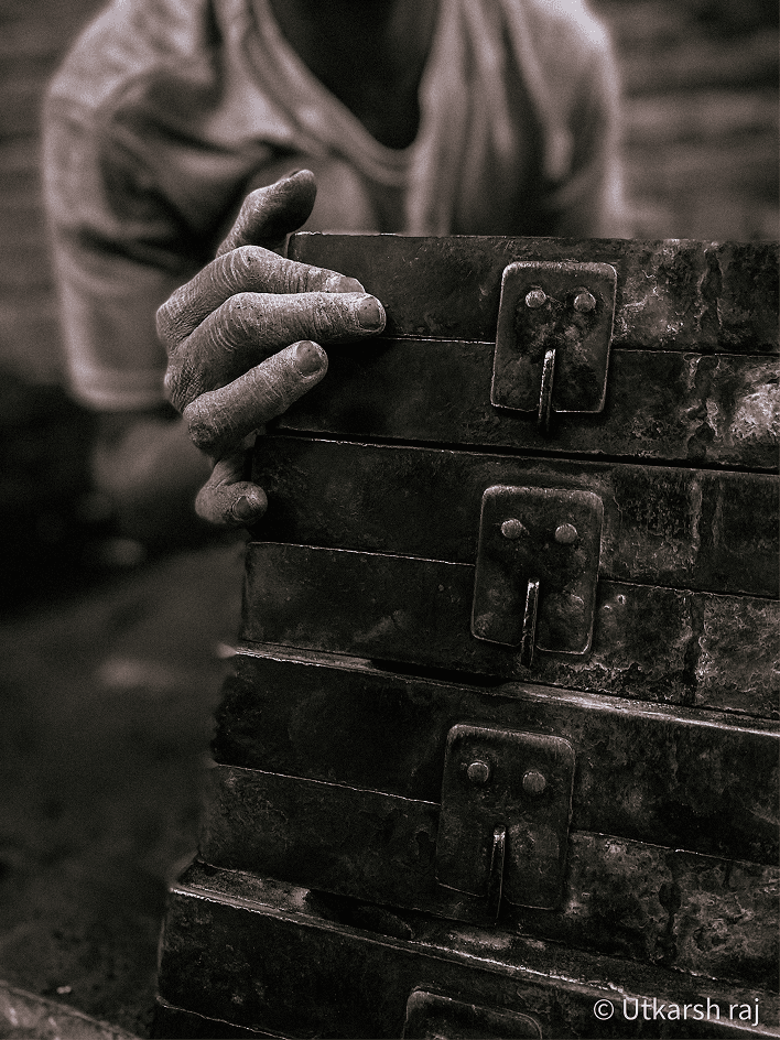 Worker's hands holding stacked metal casting moulds