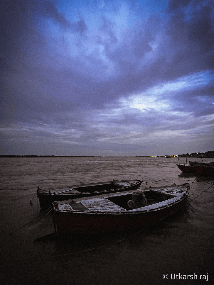 Two wooden boats moored on the Ganga at dusk