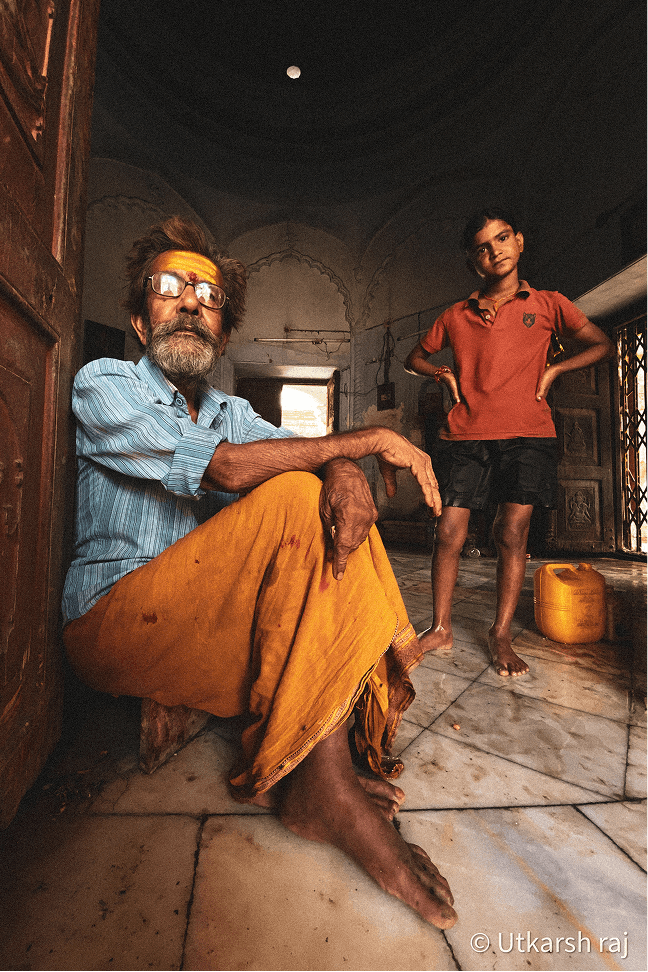 Old man with yellow headband and child inside a haveli