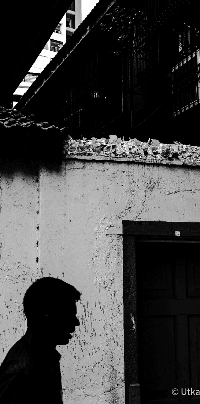 Silhouette of a man against a crumbling white wall